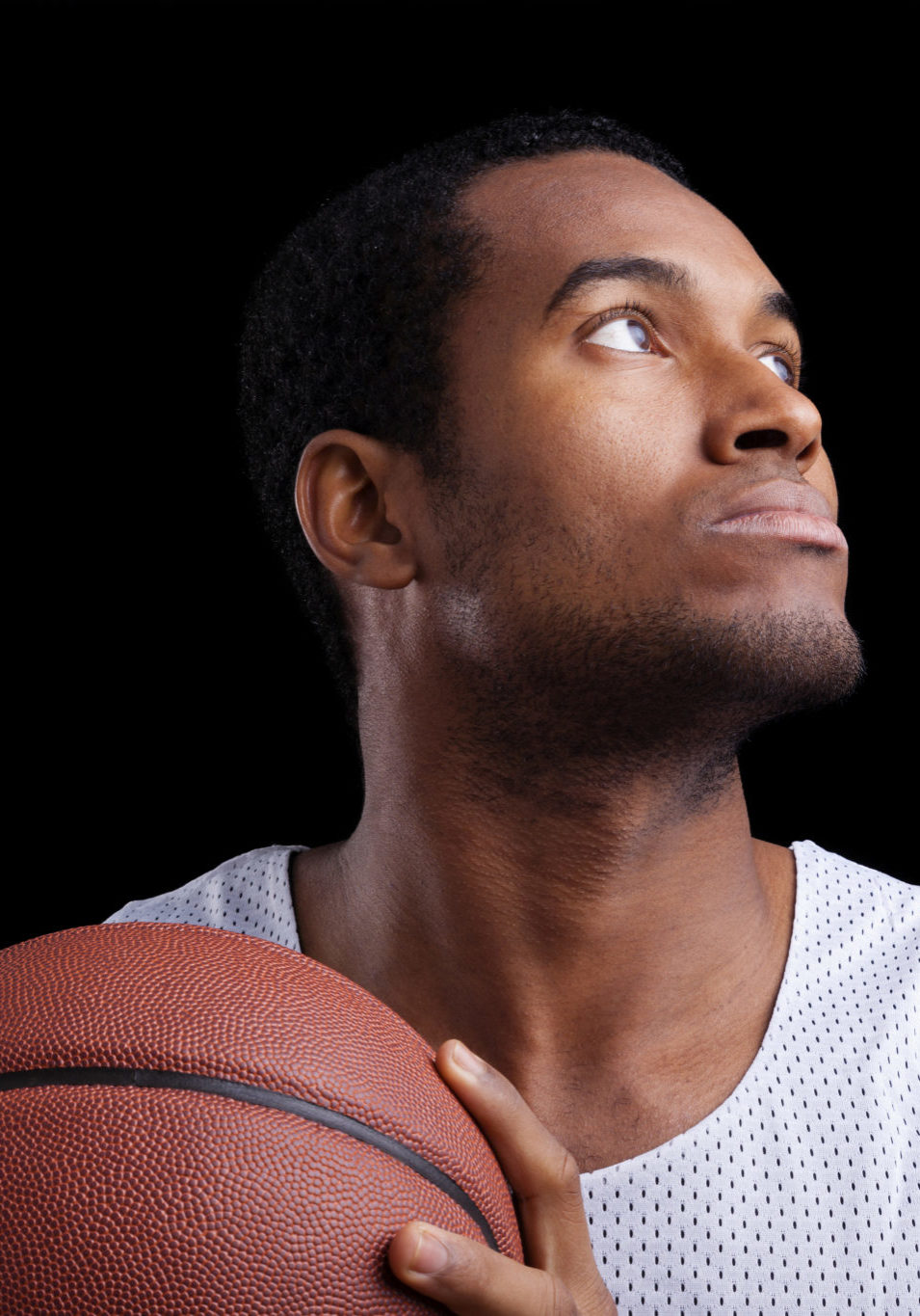 Basketball player with ball against dark background